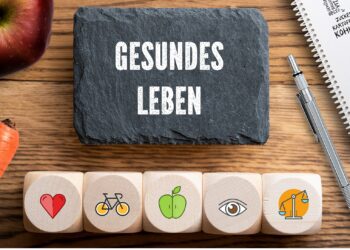 Aufschrift gesundes Leben einige Symbole, gesunde Nahrungsmittel und ein Stift und Block