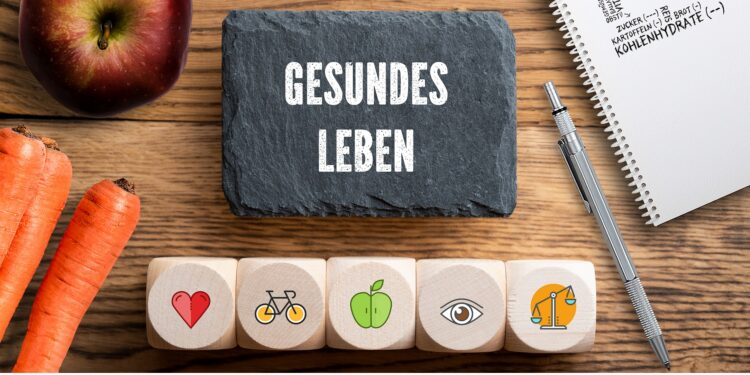 Aufschrift gesundes Leben einige Symbole, gesunde Nahrungsmittel und ein Stift und Block