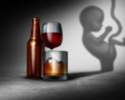 Die Abbildung zeigt einige alkoholische Getränke und im Hintergrund den Schatten eines ungeborenen Kindes.