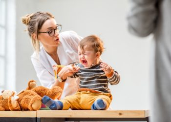 Eine Ärztin untersucht ein schreiendes Baby.