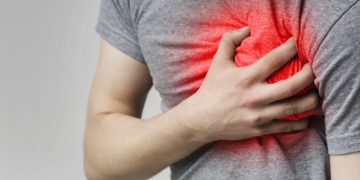 Mann mit Herzschmerzen hält die Hand auf der Brust
