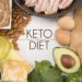 Verschiedene Lebensmittel wie Eier, Fleisch und Mandeln um den Schriftzug Keto Diet