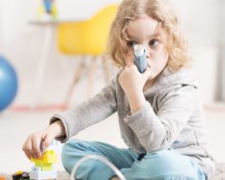 Ein junges Mädchen benutzt einen Asthma-Inhalator.