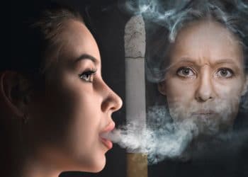 Eine junge Frau raucht eine Zigarette.