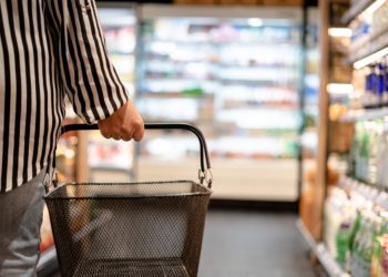 Frau mit Einkaufskorb in einem Supermarkt