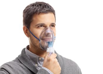 Ein Mann mit einer Sauerstoffmaske über Nase und Mund.