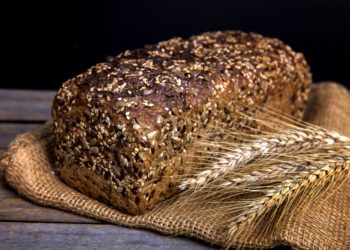 Ein Laib Vollkornbrot mit einer Getreideähre daneben