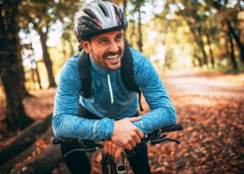 Junger Mann mit Helm auf seinem Fahrrad