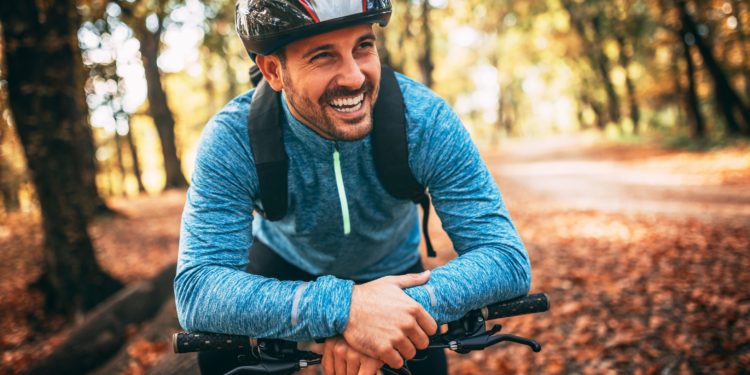 Junger Mann mit Helm auf seinem Fahrrad