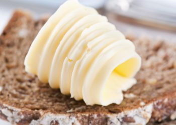 Noch nicht verstrichene Butter auf einer Scheibe Brot