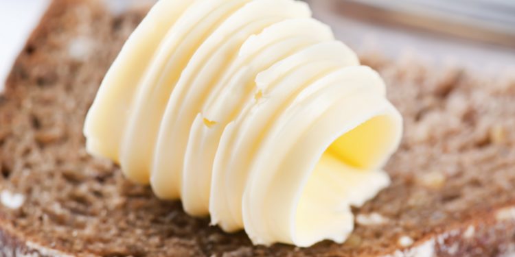 Noch nicht verstrichene Butter auf einer Scheibe Brot
