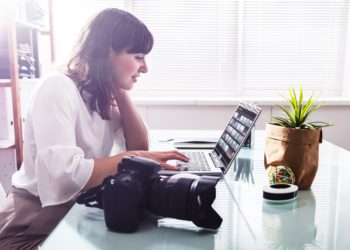 Junge Frau bearbeitet Fotos auf dem Laptop