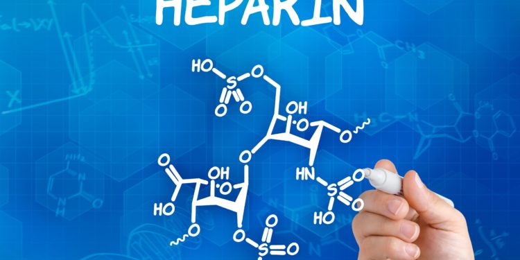 Hand mit Stift zeichnet chemische Strukturformel von Heparin