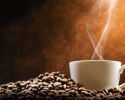 Kaffeetasse auf einem Haufen Kaffeebohnen.