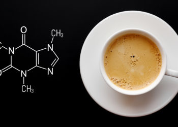 Neben einer Tasse Kaffee steht die chemische Formel für Koffein geschrieben.