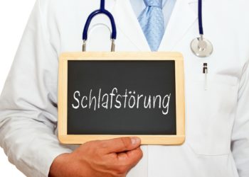 Arzt mit einer Schiefertafel, auf die das Wort Schlafstörung geschrieben ist