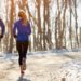 Eine Frau und ein Mann joggen in winterlicher Natur