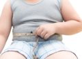 Überwichtiger Junge mit Maßband um seinen Bauch.