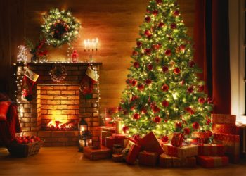 Ein geschmückter Weihnachtsbaum, unter dem Geschenke liegen.