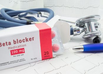 Eine geöffnete Packung Betablocker vor einem Stethoskop
