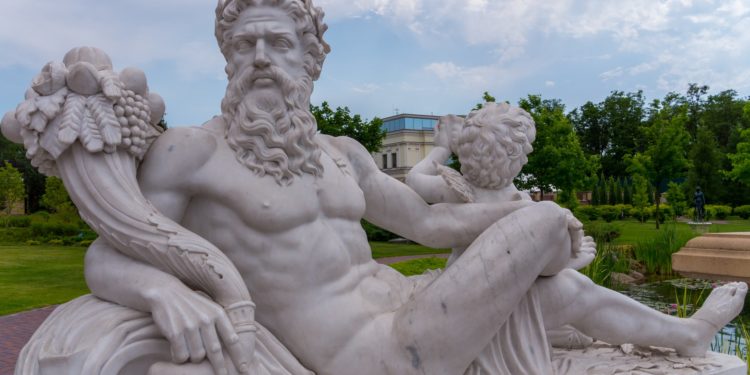 Eine Statue des sitzenden Göttervaters Zeus mit Engel und Füllhorn.