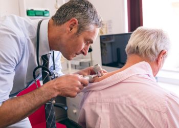 Hautarzt untersucht älteren Patienten auf Anzeichen für Hautkrebs