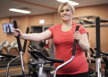 Übergewichtige Frau beim Training im Fitnessstudio