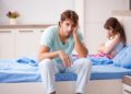 Lustloser Mann sitzt im Bett neben frustrierter Frau