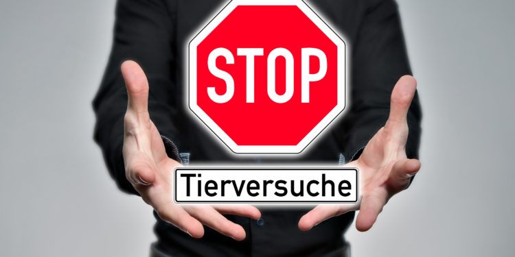 Mann hält ein virtuelles Verkehrsschild mit der Aufschrift Stop Tierversuche in den Händen