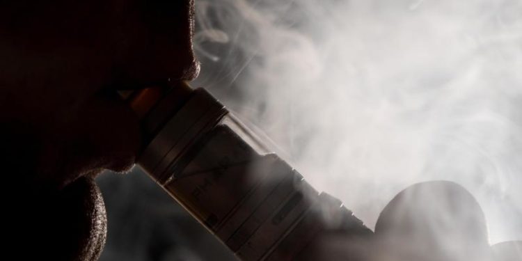 Eine Person inhaliert den Dampf einer E-Zigarette.