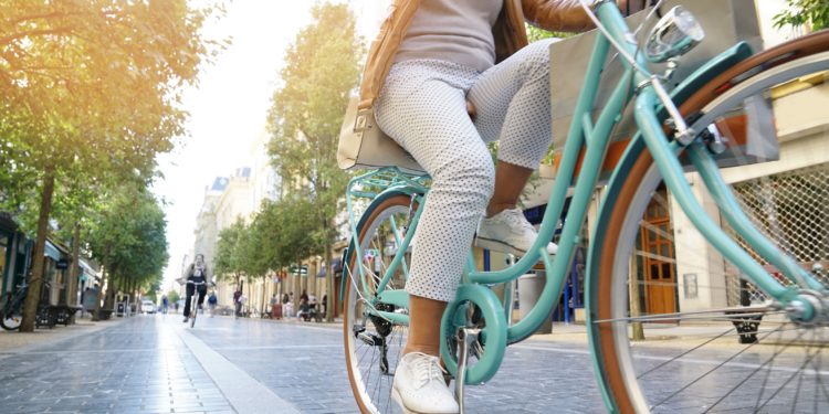 Ältere Frau fährt in der Stadt mit dem Fahrrad