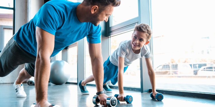 Vater und Sohn trainieren mit Hanteln