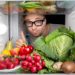 Mann öffnet seinen Kühlschrank mit gesunden Lebensmitteln.