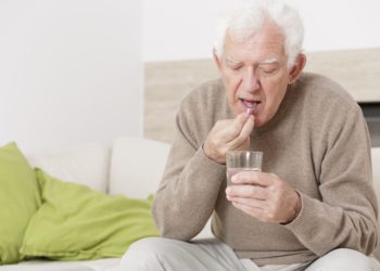 Älterer Mann nimmt eine Tablette ein