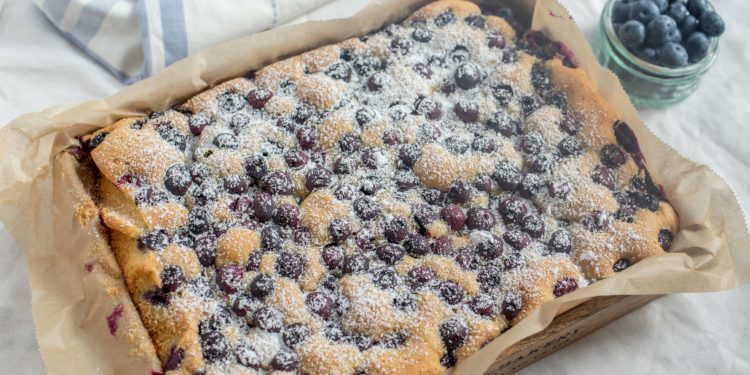 Ein Blech mit frisch gebackenem Blaubeerkuchen auf einem Tisch.