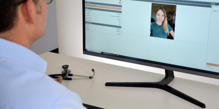 Ein Arzt telefoniert per Videochat mit einer Patientin.