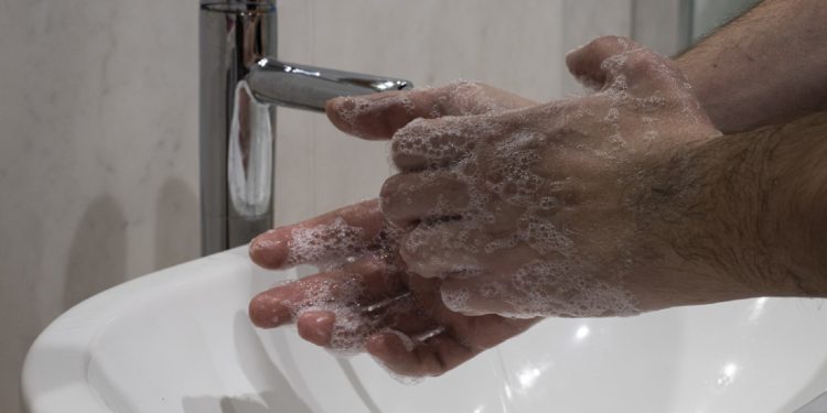 Zwei Hände, die in einem Waschbecken eingeseift werden.