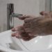 Zwei Hände, die in einem Waschbecken eingeseift werden.