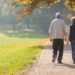 Ältere Paar geht im herbstlichen Park spazieren
