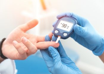 Arzt prüft bei Patienten den Blutzuckerspiegel mit einem Glukometer