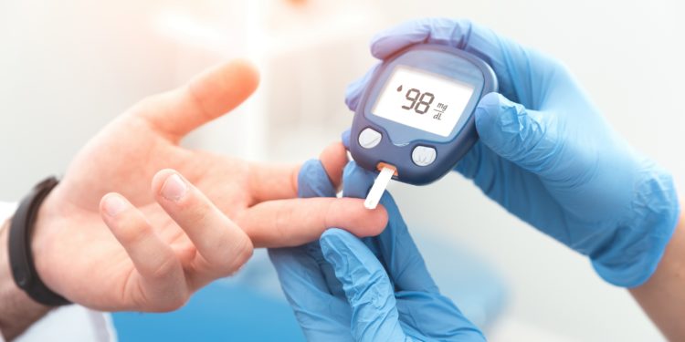 A doctor checks a patient's blood sugar level with a glucometer