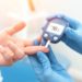 Arzt prüft bei Patienten den Blutzuckerspiegel mit einem Glukometer