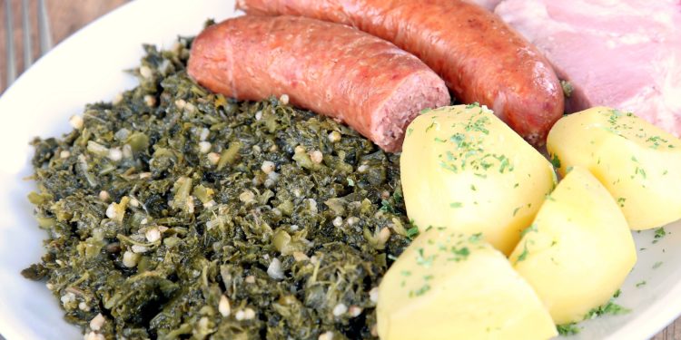 Ein Teller mit Grünkohl, Kartoffeln, Bregenwurst und Kasseler.