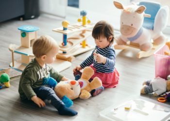 Zwei Kinder spielen in einem Kinderzimmer.