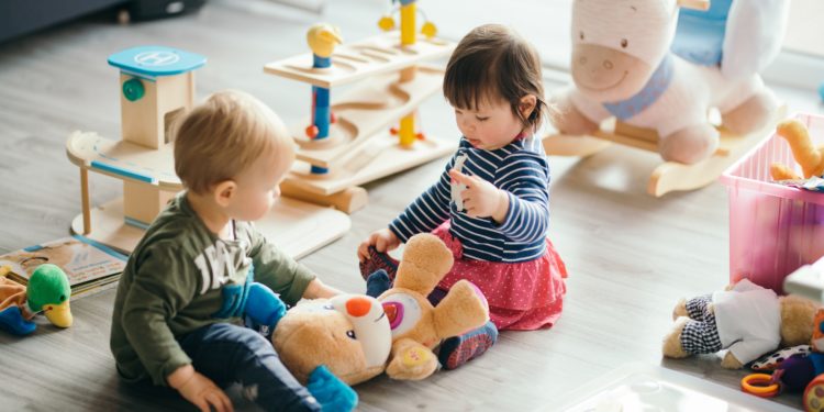 Zwei Kinder spielen in einem Kinderzimmer.