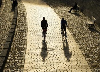Zwei Fahrradfahrer fahren auf einem Fahrradweg.
