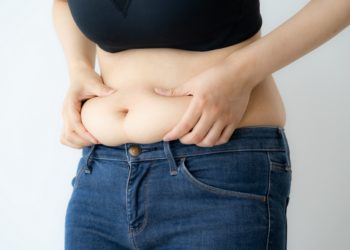 Übergewichtige Frau drückt ihren dicken Bauch