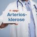Mediziner zeigt ein Schild mit der Aufschrift Arteriosklerose