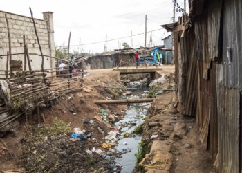 Offene Kanalisation und Blechhütten in einem Slum in Afrika