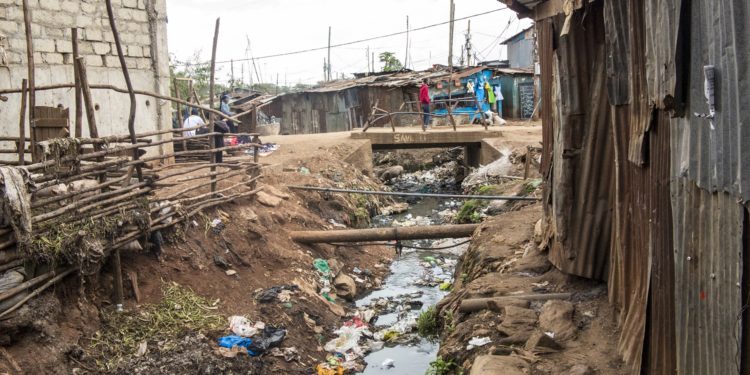Offene Kanalisation und Blechhütten in einem Slum in Afrika